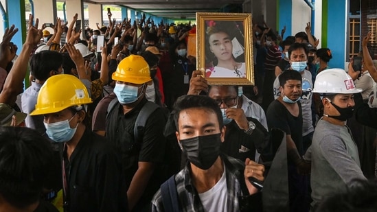 Mourners make the three-finger salute during the funeral of Chit Min Thu, a protester who died during a demonstration against the military coup on March 11, in Yangon on March 13. Three people were killed and several injured on March 13 when police opened fire on a sit-in protest in Mandalay, Myanmar's second-biggest city, two witnesses told Reuters.(AFP)