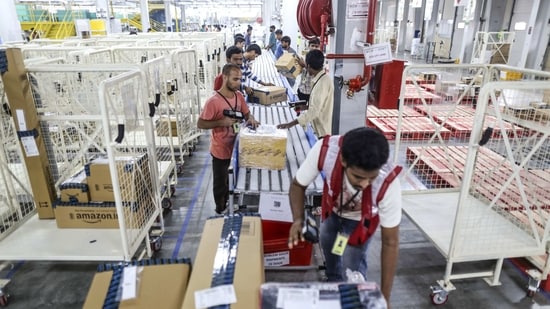 Employees work to prepare packages for shipment on the conveyor belt at the Amazon.com Inc. fulfillment center in Hyderabad,(File Photo/Bloomberg)