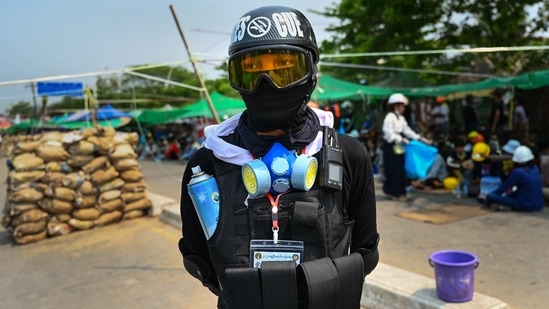 A frontline protester stands near a makeshift barricade in Yangon on March 13. The deaths came as the leaders of the United States, India, Australia and Japan vowed to work together to restore democracy in Myanmar.(AFP)