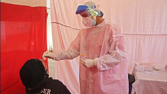 A health worker taking swab to test Covid 19 at a testing center in Pune. (Ravindra Joshi/HT PHOTO)