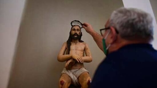 Architect Jorge Rigau arranges a crown of thorns on a statue of Jesus inside the San Jose Church, the second oldest Spanish church in the Americas, that will reopen following a massive reconstruction that took nearly two decades to complete, in San Juan, Puerto Rico, Tuesday, March 9, 2021. (AP)
