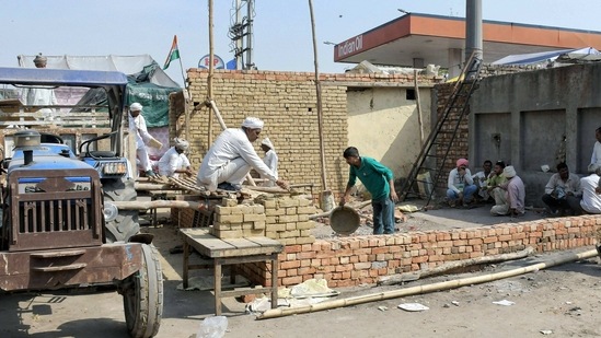 Farmers construct a brick house for shelter as the summer season approaches, during their ongoing agitation against Centre's three agri-laws, at Tikri border in New Delhi, Saturday, March 13, 2021. (PTI) Farmers construct a brick house for shelter as the summer season approaches, during their ongoing agitation against Centre's three agri-laws, at Tikri border in New Delhi, Saturday, March 13, 2021. (PTI)
