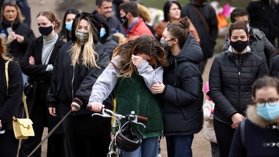 Women mourn at a memorial site at the Clapham Common Bandstand, following the kidnap and murder of Sarah Everard in London.(REUTERS)