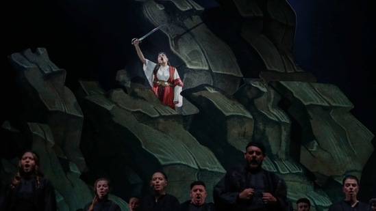 Greek soprano Artemis Bogri holding a sword, sings during a rehearsal of "Despo-Greek Dances" Opera and dance performance in Athens, Thursday, March 4, 2021. (AP)