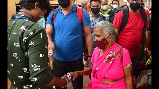 A health worker screens passengers at Dadar station. (Bhushan Koyande/ HT Photo) A health worker screens passengers at Dadar station. (Bhushan Koyande/ HT Photo)