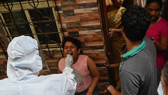 A health worker wearing protective gear takes a swab sample of a resident for a Covid-19 coronavirus test at Dharavi in Mumbai. (AFP file photo) A health worker wearing protective gear takes a swab sample of a resident for a Covid-19 coronavirus test at Dharavi in Mumbai. (AFP file photo)