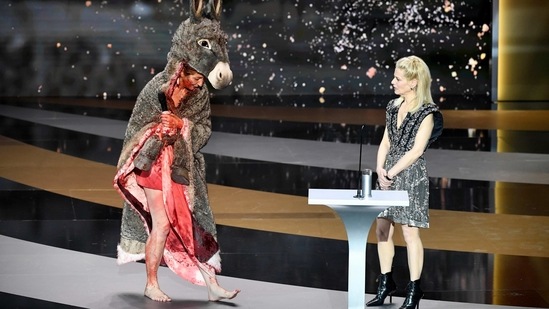 French actress Corinne Masiero (L) delivers a speech wearing a "Peau d'Ane" costume next to French actress and Master of Ceremony Marina Fois during the 46th Cesar Award ceremony on Friday, March 12, 2021 in Paris. (AP)