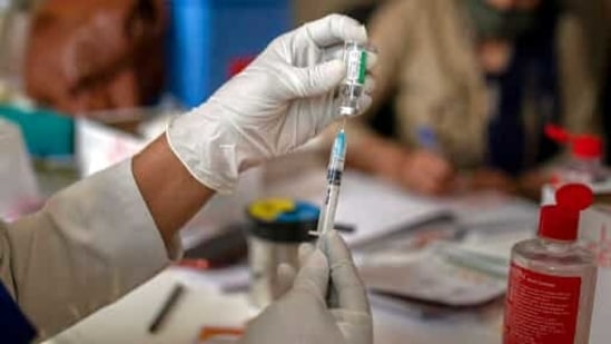 A health worker prepares to administer vaccine (AP) A health worker prepares to administer vaccine (AP)