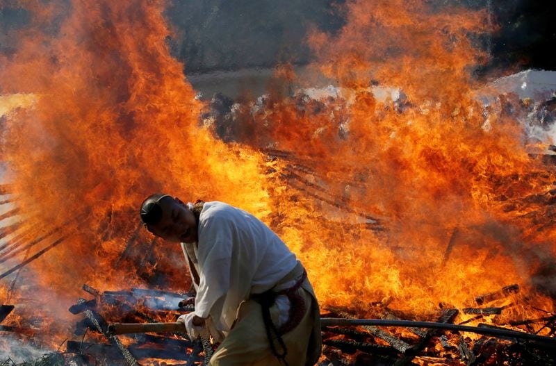 Buddhist monks spreads ambers in a bonfire at the fire-walking festival, called hiwatari matsuri in Japanese, at Mt.Takao in Tokyo. (REUTERS)