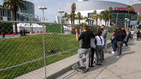 Fans wait hoping to see celebrities walk the red carpet next outside the venue on March 14. The scaled down event made for an atmosphere unlike any other Grammy show, British singer Jacob Collier told reporters. “There was something very special about how intimate it was and to have everything stripped back and just to be hanging out with those fellow nominees was just fantastic,” Collier said according to AP.(Valerie Macon/AFP)