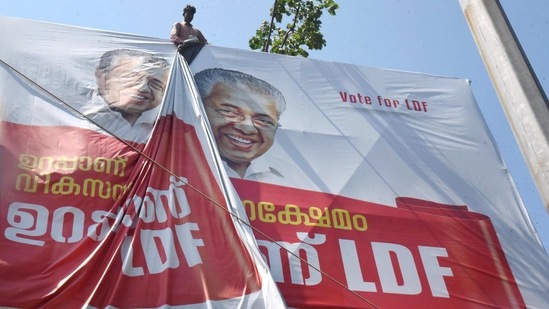 A worker puts up an election campaign banner of Kerala Chief Minister Pinarayi Vijayan, ahead of the Assembly polls, in Kochi, Friday, March 5, 2021. (PTI)