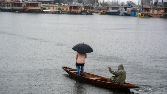 A young woman rides a boat under an umbrella during rain, at Dal Lake in Srinagar. (File photo) A young woman rides a boat under an umbrella during rain, at Dal Lake in Srinagar. (File photo)