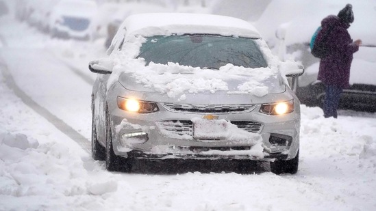 A motorist guides a sedan along North Pennsylvania Street as a snowstorm rips across the intermountain West Sunday. (AP Photo)