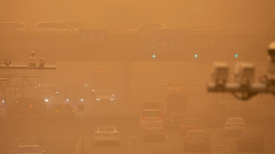 Cars are driven along a street amid a sandstorm during the morning rush hour in Beijing. (AP) Cars are driven along a street amid a sandstorm during the morning rush hour in Beijing. (AP)