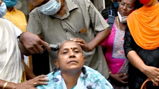 Lathika Subhash shaved her head sitting at the front courtyard of the party office as a mark of protest for being denied ticket. (HT photo by K Santhosh)