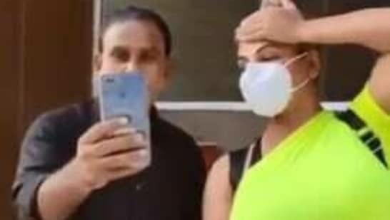 Rakhi Sawant poses for a selfie with a man.