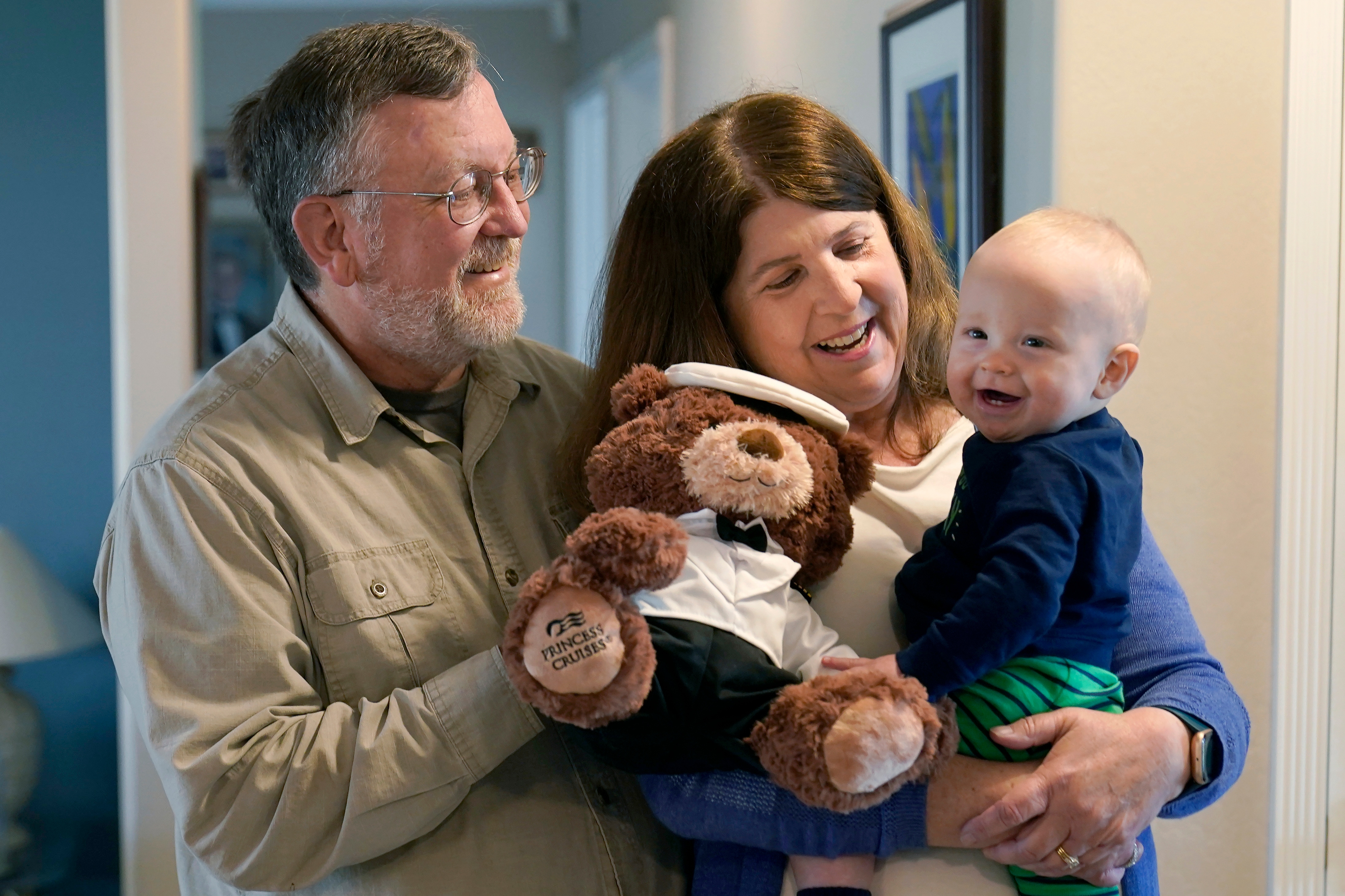John Miller, à esquerda, observa enquanto sua esposa, Laurie, segura seu neto, Theo Hamilton, enquanto é entrevistado em San Jose, Califórnia. (AP)
