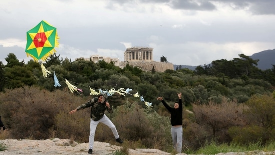 People fly a kite during celebrations of Clean Monday at Filopappou hill as the Parthenon temple is seen atop the Acropolis hill in Athens, Greece March 15, 2021. REUTERS/Costas Baltas (REUTERS)