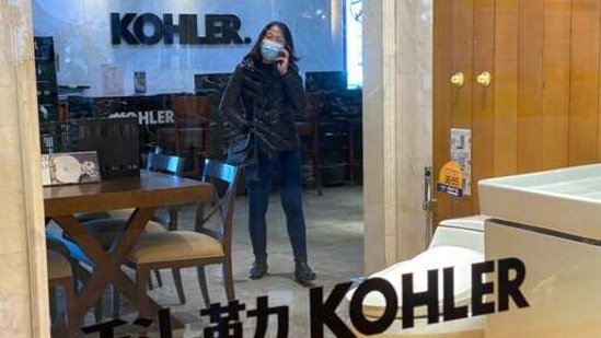 A woman wearing a face mask to help curb the spread of the coronavirus talks on her phone inside a Kohler shop in Beijing. (AP) A woman wearing a face mask to help curb the spread of the coronavirus talks on her phone inside a Kohler shop in Beijing. (AP)