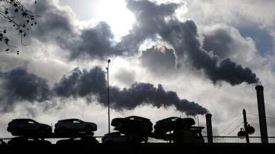 FILE - In this Friday, Nov. 30, 2018 file photo smoke rises from a factory as a truck loaded with cars crosses a bridge in Paris. Global energy-related carbon dioxide emissions rose slightly in December compared to the same month of 2019, indicating the sharp drop seen due to the pandemic was short-lived. Figures released Tuesday by the International Energy Agency show emissions from the production and use of oil, gas and coal were 2% higher in December 2020 than a year earlier. (AP Photo/Michel Euler, File)(AP)