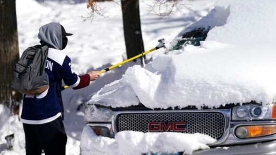 A motorist clears snow off a vehicle after a major storm dumped up to two feet of snow in its wake Monday. (AP Photo )