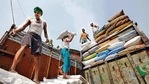 A labourer carries a sack filled with sugar to load it onto a supply truck at a wholesale market in Kolkata. (Reuters)