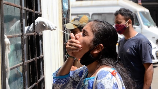 A health worker collects a swab sample from a woman to test for Covid-19 infection, at Bai Rukminibai Hospital, in Kalyan, on March 13. After witnessing the peak of the first wave on September 17 with 24,619 cases, the daily caseload in Maharashtra had dropped to as low as fewer than 2,000 cases in the first week of February, HT reported.(Rishikesh Choudhary / HT Photo)