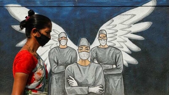A woman wearing a face mask walks past a Covid-19 graffiti in Navi Mumbai, on March 8. Meanwhile, Maharashtra health minister Rajesh Tope met with Union health minister Harsh Vardhan on March 16 and requested to release 2 million doses of vaccine per week, enabling Maharashtra to inoculated 1.77 crore people from the priority groups that are being vaccinated, HT reported.(Francis Mascarenhas / REUTERS)