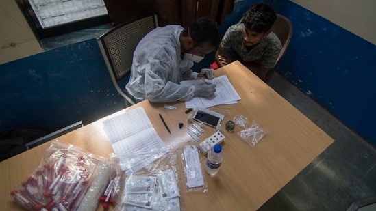 A health worker notes details from a man during a swab collection drive, at Govandi in Mumbai, on March 14. After reporting 1,927 infections on February 2, cases started rising Maharashtra and the state reported 17,864 cases on March 16—the highest single-day spike after 167 days (18,317 cases were clocked on September 30), HT reported.(Pratik Chorge / HT Photo)
