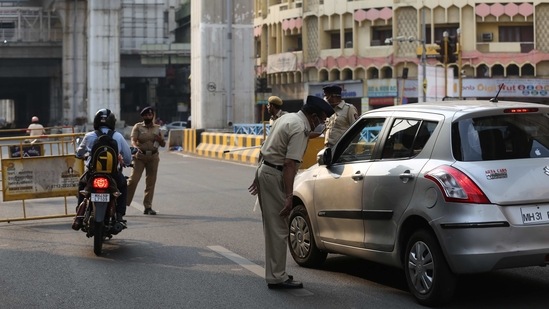 Police personnel check vehicles at CA Road during a week-long lockdown declared after a surge in Covid-19 cases, in Nagpur, on March 15. Maharashtra on March 16 reported 87 deaths. The case fatality rate (CFR) of the state stood at 2.49% and the recovery rate at 95.66%, HT reported.(HT Photo)