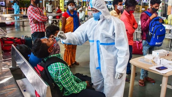 A health worker takes a swab sample of a passenger for coronavirus tests at the CSMT railway station on Wednesday.(PTI)