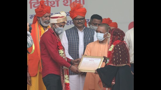 Uttar Pradesh chief minister Yogi Adityanath handing over marriage certificate to a newly wed couple at a mass marriage ceremony in Lucknow on Thursday. (Deepak Gupta/HT) Uttar Pradesh chief minister Yogi Adityanath handing over marriage certificate to a newly wed couple at a mass marriage ceremony in Lucknow on Thursday. (Deepak Gupta/HT)