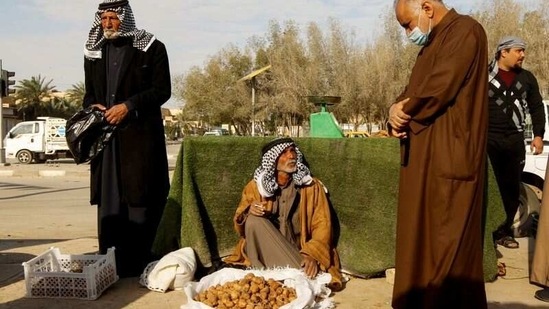 A truffle seller interacts with a customer at a market in the city of Samawa, on February 22. With Iraq's economy in crisis, the local variety of truffles are a big help to Buheir and her family. This year the rain came late and Buheir could only find about a kilo of truffles a day, one-tenth of what she would dig up in a good year.(Alaa Al-Marjani / REUTERS)