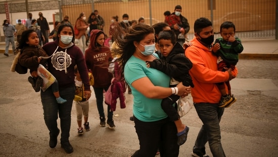 Asylum-seeking migrants from Central America, who were airlifted from Brownsville to El Paso, Texas, and deported from the US, walk near the Paso del Norte international border bridge in Ciudad Juarez, Mexico, on March 16. The Border Patrol took in an additional 561 on March 15, twice the recent average, a US official told AP on condition of anonymity to discuss figures not yet publicly released.(Jose Luis Gonzalez / REUTERS)
