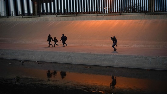 Migrants cross the border into El Paso, Texas, US, as seen from Ciudad Juarez, in Mexico, on March 17. The number of migrants attempting to cross the border is at the highest level since March 2019, with Homeland Security Secretary Alejandro Mayorkas warning that it is on pace to hit a 20-year peak.(Paul Ratje / REUTERS)