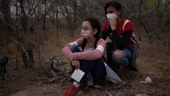 Asylum seeking unaccompanied minors Angie, 11, and Elene, 15, from Honduras, await transport by US Border Patrol agents after crossing the Rio Grande river into the United States from Mexico on a raft in La Joya, Texas, on March 14. According to the most recent statistics released publicly by US Customs and Border Protection, children and teens crossing by themselves rose 60% from this January to more than 9,400 in February.(Adrees Latif / REUTERS)