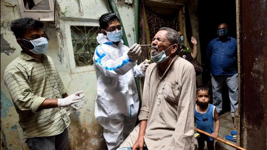 A BMC healthcare worker collects swab samples of Dharavi residents. (Satish Bate/HT Photo) A BMC healthcare worker collects swab samples of Dharavi residents. (Satish Bate/HT Photo)
