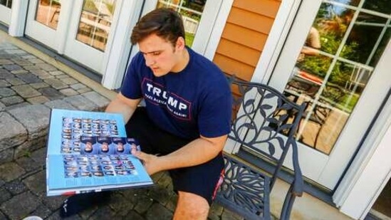 A student at Wall High School flips through his 2017 school yearbook which includes a photo of him wearing a digitally altered T-shirt. (AP)