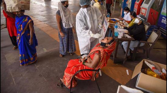 A medic from NMMC Hospital takes a swab sample from a commuter for Covid-19 testing, at Turbhe Railway Station in Navi Mumbai, on March 15. (PTI)