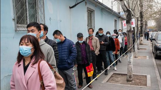 People wait in line outside a Covid-19 vaccination centre in Beijing, China on Wednesday. (Bloomberg)