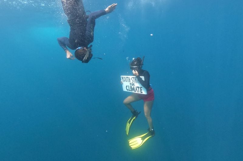 Shaama Sandooyea holds a placard reading Youth Strike For Climate, during an underwater protest at the Saya de Malha Bank. (REUTERS)