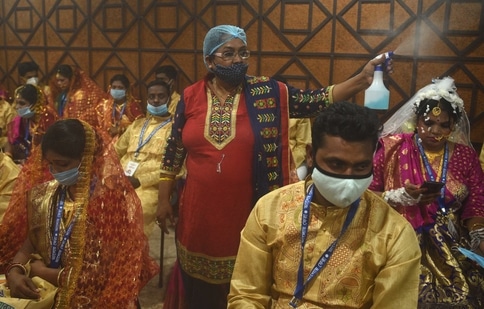 A woman disinfect premises during a mass marriage ceremony in Kolkata. (Samir Jana/Hindustan Times)