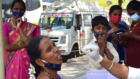 A health worker conducts COVID-19 testing of a passenger at KSRTC bus stand, amid surge in coronavirus cases in Bengaluru. (PTI Photo) A health worker conducts COVID-19 testing of a passenger at KSRTC bus stand, amid surge in coronavirus cases in Bengaluru. (PTI Photo)