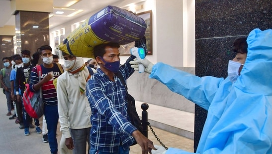 Maharashtra, which is the worst hit as a second wave of infections starts in India, ordered all theatres and auditoriums to operate at 50% capacity, and allow no one to enter without masks. In this file picture, a frontline worker checks temperature of people in Mumbai. (PTI)