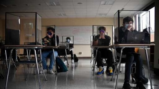 The new guidelines also remove recommendations for plastic shields or other barriers between desks. (AP / File) The new guidelines also remove recommendations for plastic shields or other barriers between desks. (AP / File)