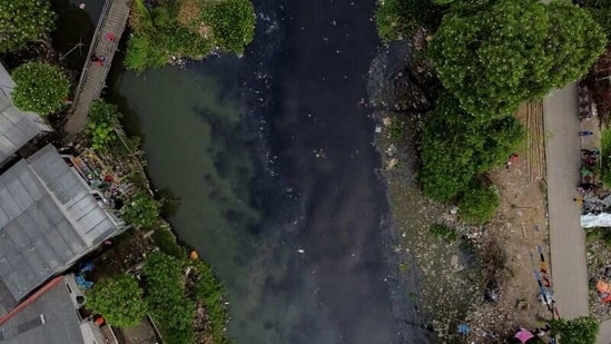 An aerial view shows people fishing from a wooden bridge at the Pisang Batu river, which flows through a densely populated area and is polluted by domestic waste, in Bekasi, on the outskirts of Jakarta, Indonesia, on March 16, 2021. Pisang Batu river, on the outskirts of Jakarta, made national headlines in 2019 after plastic garbage and organic waste from nearby households completely covered its surface stretching 1.5 kilometres, Reuters reported.(Willy Kurniawan / REUTERS)