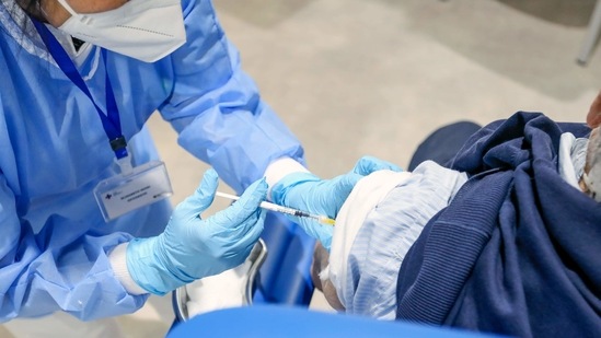 A health worker administers the Moderna Inc. Covid-19 vaccine to a visitor at a Covid-19 vaccination center (Bloomberg) A health worker administers the Moderna Inc. Covid-19 vaccine to a visitor at a Covid-19 vaccination center (Bloomberg)