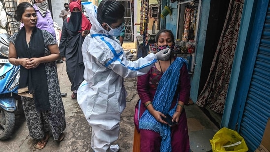 A health worker collects a nasal swab sample from a woman at a residential area in Mumbai.(AFP) A health worker collects a nasal swab sample from a woman at a residential area in Mumbai.(AFP)