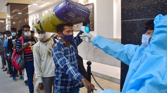 A healthcare worker conducts thermal screening of a passenger at CSMT Railway Station in Mumbai on Wednesday, as Covid-19 cases spike across Maharashtra.(PTI Photo)