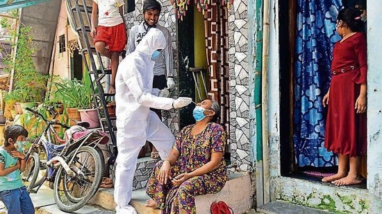 A BMC medical staffer collects the swab sample of a resident at Dharavi on Tuesday. (Anshuman Poyrekar/HT Photo) (HT_PRINT) A BMC medical staffer collects the swab sample of a resident at Dharavi on Tuesday. (Anshuman Poyrekar/HT Photo) (HT_PRINT)